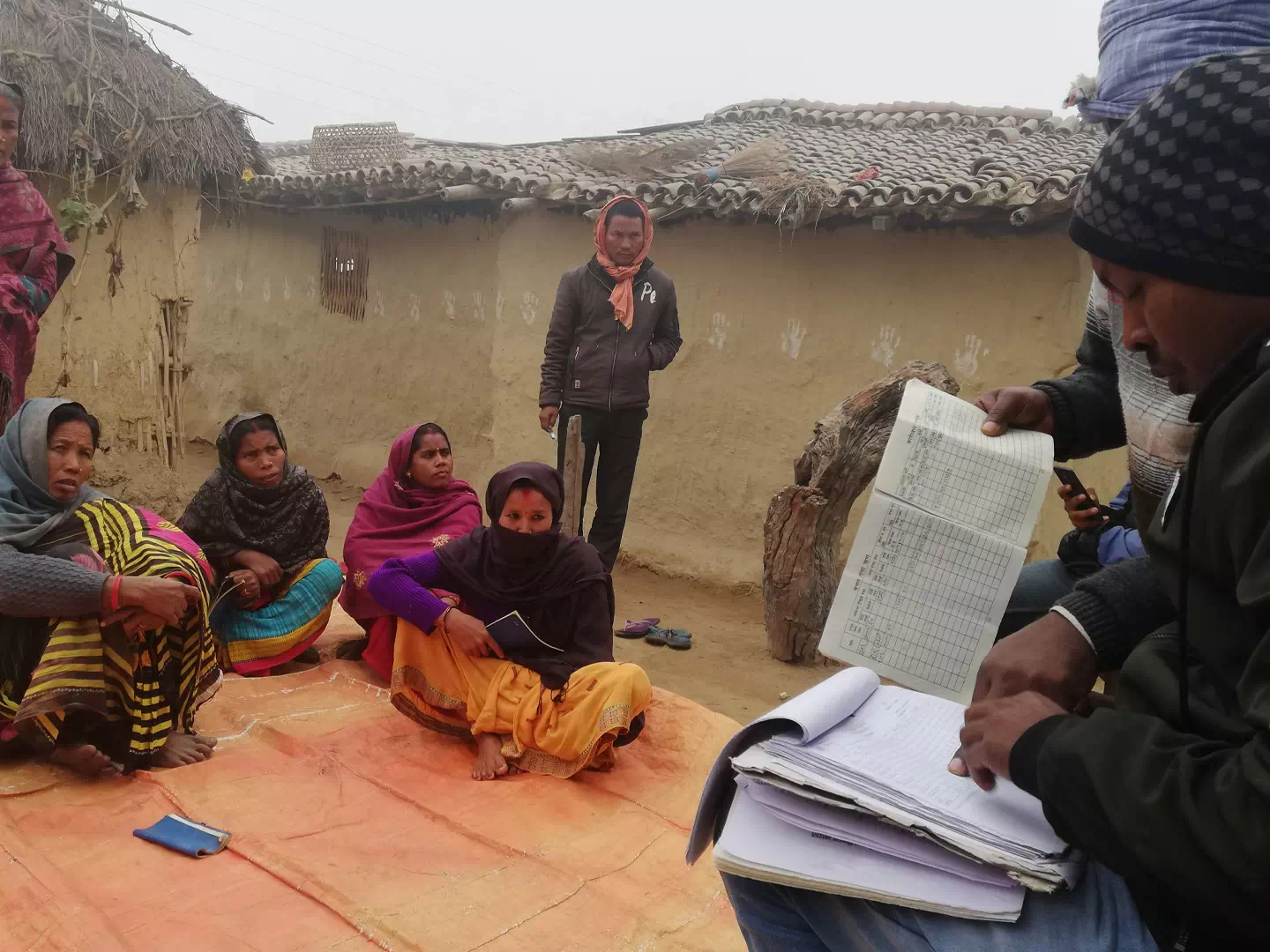 Microfinance staff talking with farmers during field research